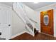 Bright entryway with hardwood floors, a wooden staircase, and a glass-paneled door at 12 Fairway Ln, Peachtree City, GA 30269