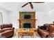Cozy living room featuring a stone fireplace and leather furniture at 12 Fairway Ln, Peachtree City, GA 30269