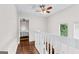 Upstairs hallway with wood floors and access to bedrooms at 12 Fairway Ln, Peachtree City, GA 30269