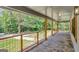 Covered porch with stone patio, wooden swing, and scenic wooded view at 2752 Poplar Rd, Sharpsburg, GA 30277