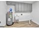 Laundry room with utility sink, cabinets and water heater at 2752 Poplar Rd, Sharpsburg, GA 30277