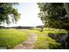 Large backyard with grassy area, trees, and outbuilding at 10 Maranatha Rd, Mcdonough, GA 30252