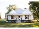 White farmhouse with a front porch, landscaping, and large yard at 10 Maranatha Rd, Mcdonough, GA 30252