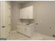 Laundry room with white cabinets and quartz countertops at 230 Waltham Way, Fayetteville, GA 30214