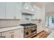 Modern kitchen with white cabinets, stainless steel range and a vent hood at 1055 Church St, Smyrna, GA 30080