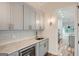 Elegant wet bar with gray cabinets, marble countertops, and wine cooler at 1055 Church St, Smyrna, GA 30080