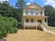 Two-story yellow house with front porch and steps at 321 Seventh Ave, Scottdale, GA 30079