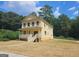 Two-story yellow house with a front porch and landscaped yard at 321 Seventh Ave, Scottdale, GA 30079