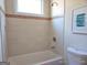 Clean bathroom with tub shower, window, and tile surround at 321 Seventh Ave, Scottdale, GA 30079