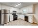 Galley kitchen with white cabinets and stainless steel appliances at 5868 Dan Dr, Ellenwood, GA 30294