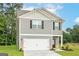 Two story home with gray siding, white garage door, and landscaping at 134 Avondale Blvd, Conyers, GA 30013