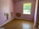 Small bedroom with light pink walls and wood flooring at 175 Moss Dr, Mcdonough, GA 30252