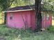 Pink shed in overgrown backyard setting at 175 Moss Dr, Mcdonough, GA 30252