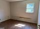Small bedroom with plain walls and wood-look flooring at 175 Moss Dr, Mcdonough, GA 30252