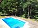Inviting blue swimming pool, surrounded by lush greenery at 7505 Hall Rd, Fairburn, GA 30213