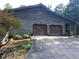 Two-car garage with wooden doors and a long driveway at 7505 Hall Rd, Fairburn, GA 30213