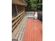 Long wooden deck bench with red stained wood at 2531 Quentin Dr, Jonesboro, GA 30236