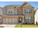 Two-story brick house with a large front yard and three car garage at 3290 Stock Saddle Pl, Cumming, GA 30040
