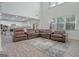 Spacious living room featuring a sectional sofa and views into the kitchen at 3290 Stock Saddle Pl, Cumming, GA 30040