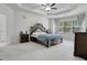 Main bedroom with a large bed, nightstands, and carpet flooring at 3290 Stock Saddle Pl, Cumming, GA 30040