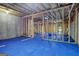 Unfinished basement with blue flooring and framed walls at 3290 Stock Saddle Pl, Cumming, GA 30040