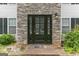 Stone accented entrance with black door and glass panels at 1125 Misty Meadows Ln, Hampton, GA 30228