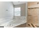 Bathroom with corner bathtub, shower, and marble tile at 1125 Misty Meadows Ln, Hampton, GA 30228