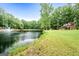 Pond view of house with fountain, lush green grass, and trees at 3110 Highway 20 W, Hampton, GA 30228