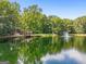 House on a pond with lush green trees and a fountain at 3110 Highway 20 W, Hampton, GA 30228