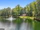 Aerial view of house on a pond with lush green trees and a fountain at 3110 Highway 20 W, Hampton, GA 30228