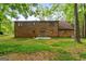 Brick house back view, showcasing a patio and tree-lined yard at 3110 Highway 20 W, Hampton, GA 30228