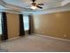 Large main bedroom with neutral carpeting and ceiling fan at 1218 Heartwood Ave, Mcdonough, GA 30253