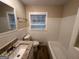Clean bathroom with white tile, granite countertop vanity, and a bathtub at 3207 Cloverhurst Dr, East Point, GA 30344