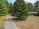 Aerial view showing a long driveway leading to a cozy ranch house at 1142 Harbins Rd, Dacula, GA 30019