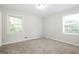 Bedroom with neutral walls, carpet, and two windows at 7325 Czar Pl, Riverdale, GA 30296