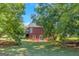 Brick house with a deck, nestled among mature trees in the backyard at 825 S Bethany Rd, Locust Grove, GA 30248
