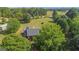 Aerial view of a house with a large yard and surrounding woods at 825 S Bethany Rd, Locust Grove, GA 30248