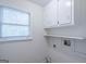 Bright laundry room with upper cabinets, shelving and window at 3142 Brooks Dr, Snellville, GA 30078