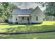 Charming white farmhouse with a wraparound porch at 27 Smith St, Locust Grove, GA 30248
