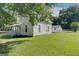 Side view of a white farmhouse with a detached building at 27 Smith St, Locust Grove, GA 30248