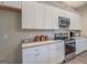 White shaker cabinets, granite countertops, and stainless steel appliances at 2 Poplar St, Porterdale, GA 30070