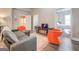 Living room with grey couch and orange accent chairs, view into bedroom at 2 Poplar St, Porterdale, GA 30070