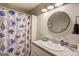 Bathroom with a shower/tub combo, a round mirror, and a granite vanity at 2 Poplar St, Porterdale, GA 30070