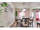 Bright dining room featuring a spacious table and chairs, complemented by red curtains at 11341 Freeman Way, Hampton, GA 30228