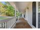 Inviting front porch with wooden flooring and white railing, overlooking a tree-lined street at 125 Laney Ct, Mcdonough, GA 30252