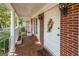 Inviting front porch with brick facade, columns, and terracotta tile floor at 4850 Lehigh Dr, Douglasville, GA 30135