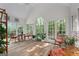 Sun-drenched sunroom with hardwood floors, wicker furniture, and abundant natural light at 270 Emerald Lake Dr, Fayetteville, GA 30215