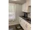 Kitchen with white cabinets, gray countertops, and LVP flooring at 2734 Laurel View Dr, Snellville, GA 30039
