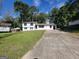 Front view of a white house with black windows and a long driveway at 6517 Revena Dr, Morrow, GA 30260