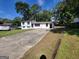 Front view of a white house with black windows and a long driveway at 6517 Revena Dr, Morrow, GA 30260